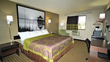 A hotel room with a large bed, a desk, a chair, a TV, and a window with curtains.