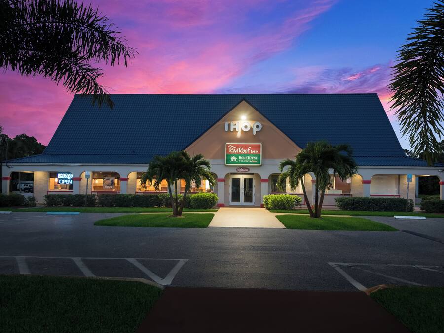 A hotel with a 'Shop' sign, a 'Welcome' entrance, and a 'Red Roof Inn' sign.
