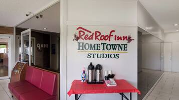 Señal de RedRoof Inn HOME TOWNE STUDIOS con una mesa que muestra cafeteras y tazas.