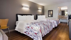A hotel room with a large bed, a chair, a desk, and a mirror. - Red Roof Inn Vero Beach - I-95 (Vero Beach)