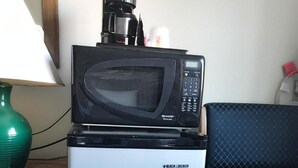 A small black microwave on top of a white mini-fridge with the brand 'BLACK & DECKER' visible. - Best Inn (Petersburg)