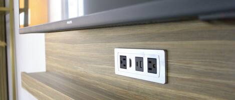 A wall with a wooden panel and a power outlet.