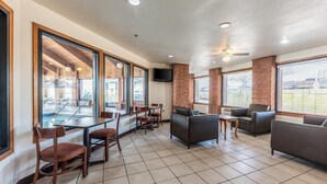 A spacious indoor area with a pool view, a seating area with couches and chairs, and a television mounted on the wall. - Econo Lodge Inn & Suites Mckinney - Plano North (McKinney)