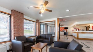 A spacious lobby with a reception desk, a seating area with sofas and a coffee table, and large windows with blinds. - Econo Lodge Inn & Suites Mckinney - Plano North (McKinney)