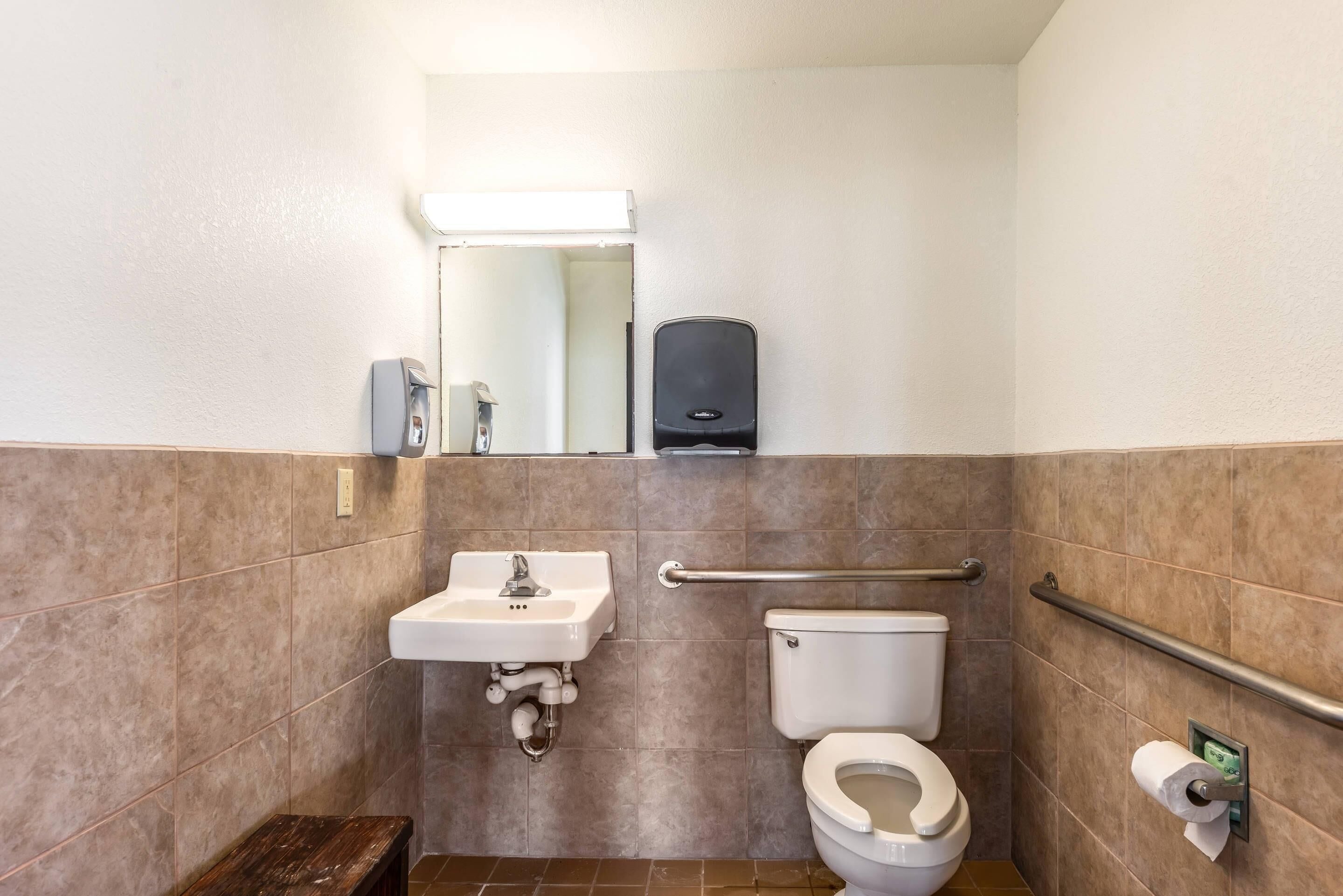 Une petite salle de bain avec un lavabo, des toilettes et un sèche-mains.
