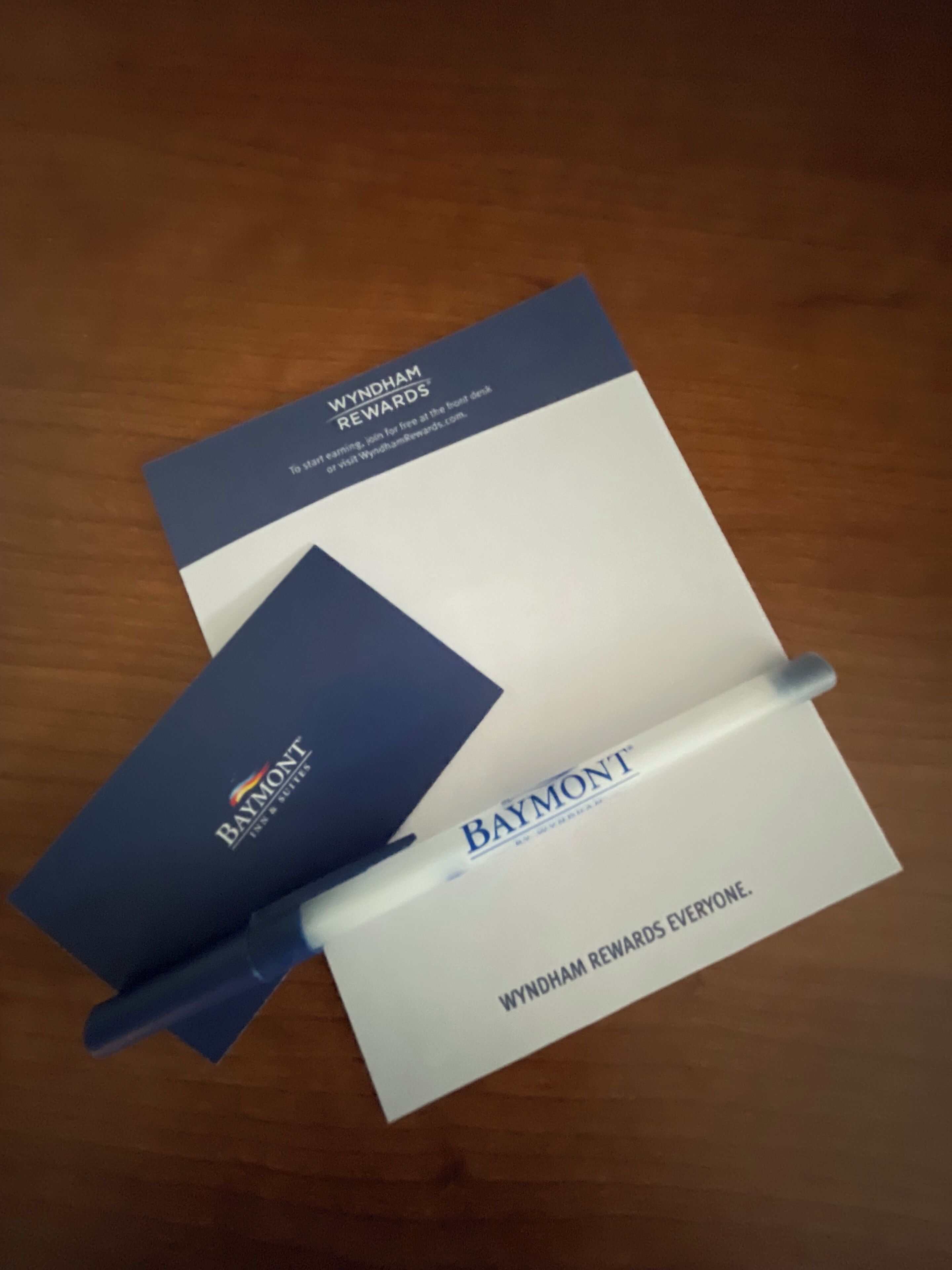 A brochure for Wyndham Rewards and a pen on a wooden surface.