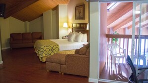 Un dormitorio con una cama, dos sofás, una silla y un balcón con vistas.