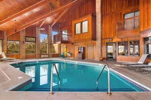 Relax by the rectangular pool surrounded by a tiled deck and lounge chairs.
