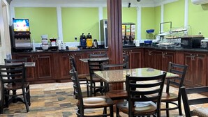 A restaurant with wooden furniture, a coffee machine, and a TV screen. - SureStay by Best Western Grove City (Grove City)