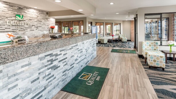 A reception area with a stone wall, a reception desk, and a seating area with patterned chairs.