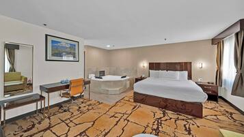 Quarto de hotel com uma cama grande, uma escrivaninha, uma cadeira, uma banheira e uma janela ampla com cortinas.