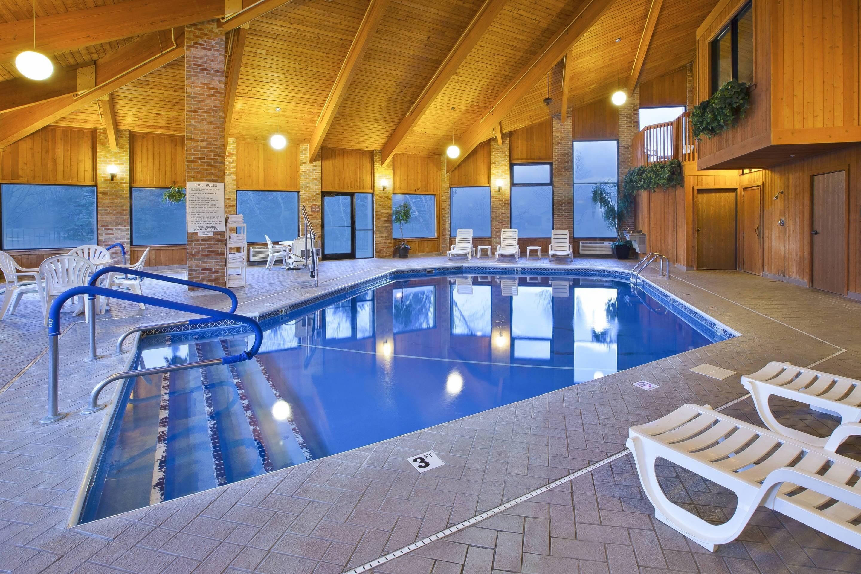 Una piscina techada, sillones reclinables de piscina