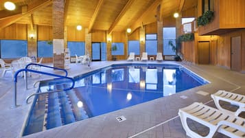 Una piscina techada, sillones reclinables de piscina