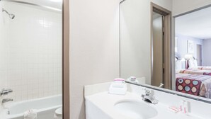 Un baño con bañera, lavamanos y espejo.