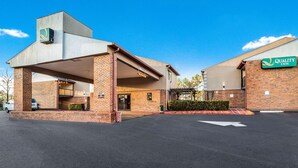 A hotel with a brick facade, a covered entrance, and a sign for Quality Inn. - Quality Inn Columbia Airport (West Columbia)