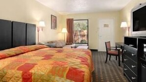 A hotel room with a bed, a desk, a chair, a TV, and a dresser. - Super 8 by Wyndham Decatur/Lithonia/Atl Area (Decatur)