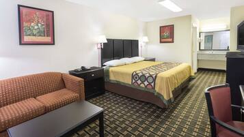 A hotel room with a bed, a sofa, a desk, and a chair.