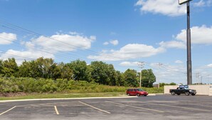 A parking lot with a Knights Inn sign, a red car, and a blue truck. - Knights Inn Lebanon (Lebanon)