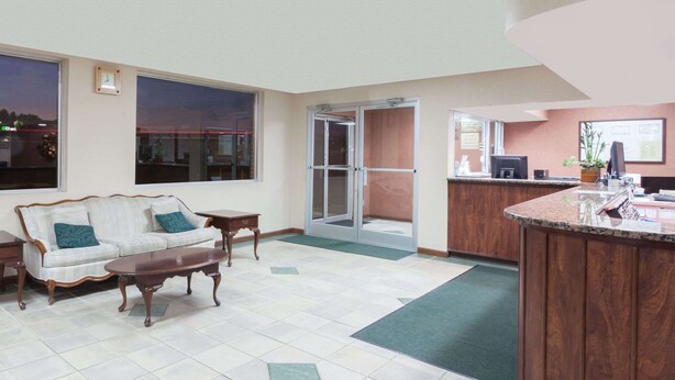 A hotel lobby with a sofa, coffee table, and a reception desk. - Knights Inn Lebanon (Lebanon)