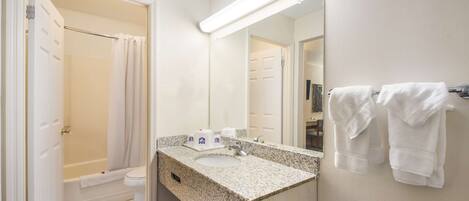 A bathroom with a sink, mirror, and towels.
