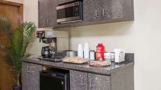 A kitchenette with a microwave, coffee maker, and various kitchen items on the counter. - Knights Inn Cleveland, TN (Cleveland)
