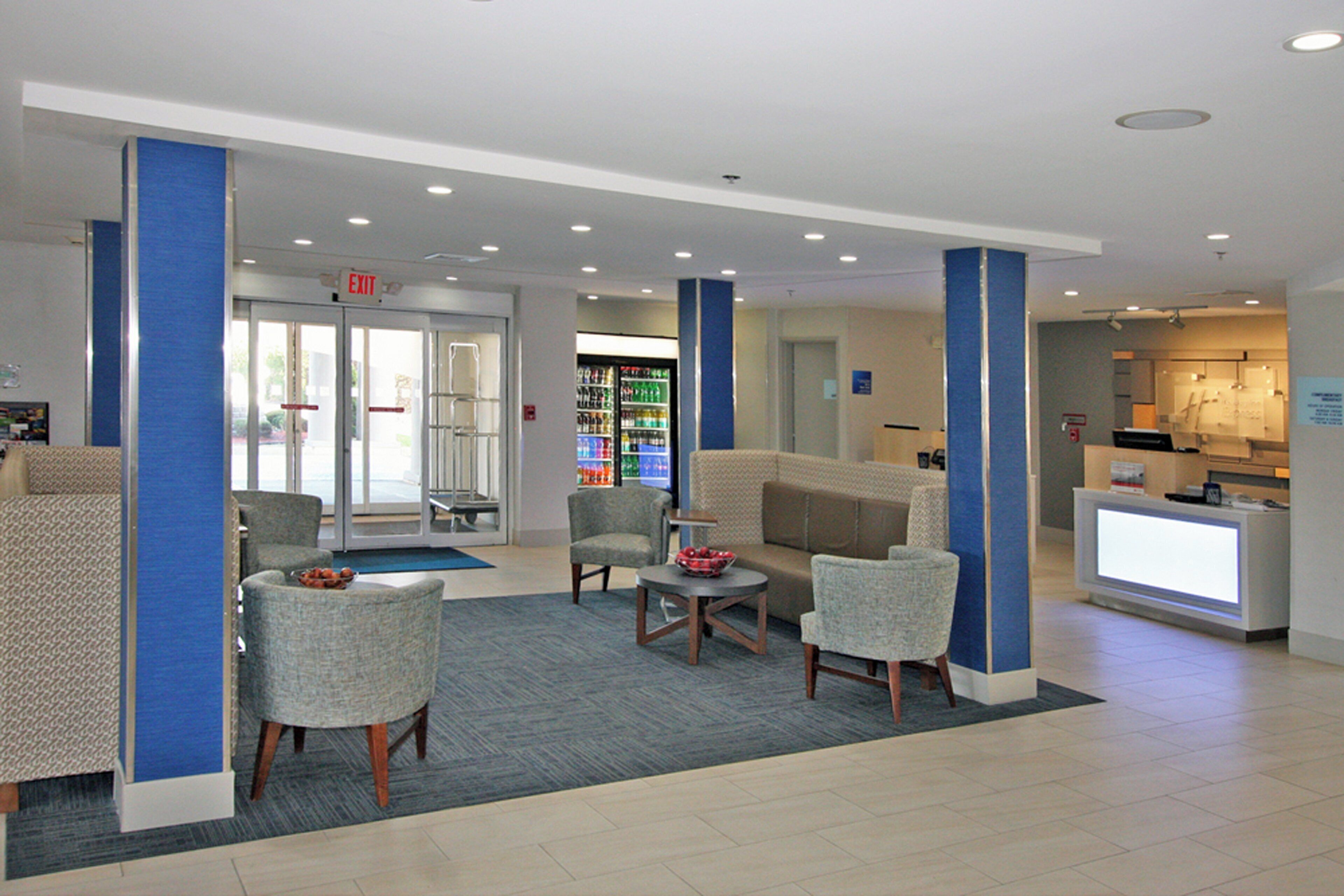 A lobby with seating, a reception desk, and a vending machine.