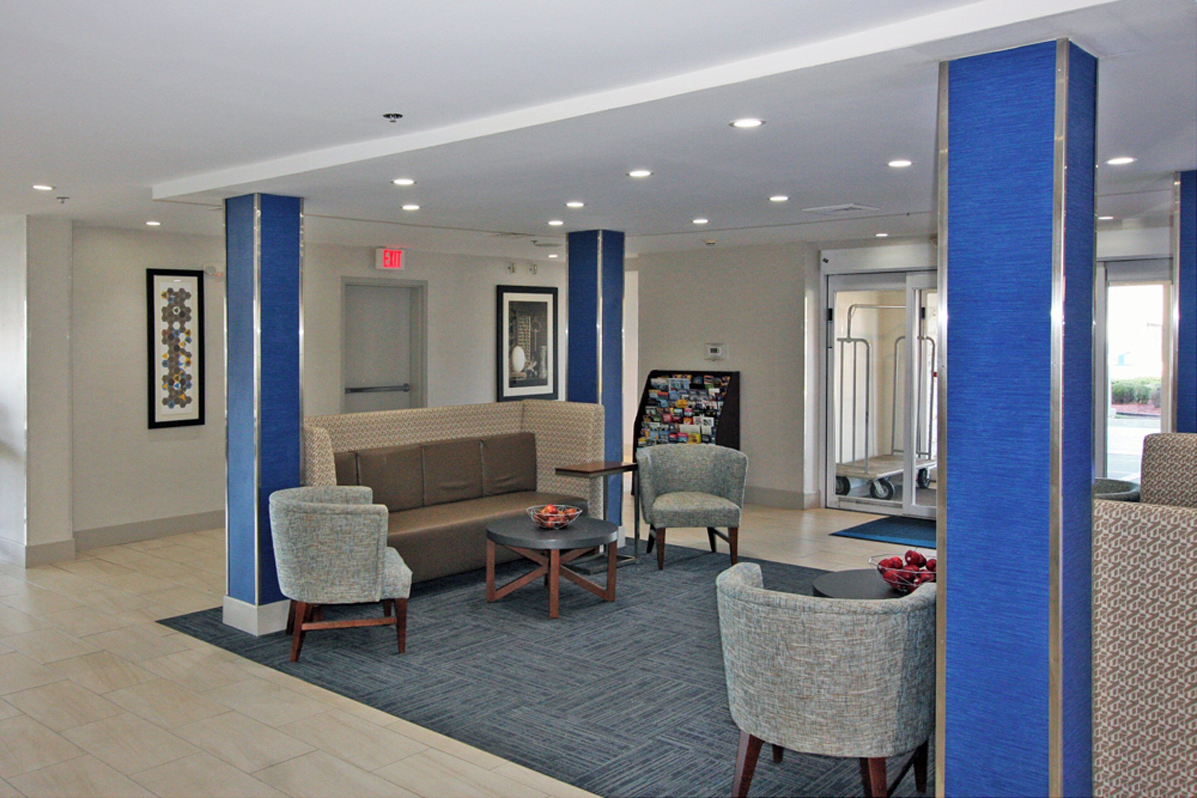 A lobby with a sofa, chairs, a coffee table, and a bookshelf.