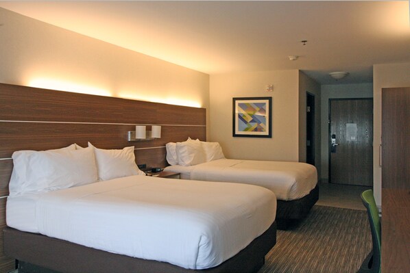 A hotel room with two beds, a wooden headboard, a framed picture on the wall, and a door in the background. - Holiday Inn Express Branford-New Haven by IHG (Branford)