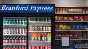 A refrigerated display case with a sign reading "Branford Express" and shelves stocked with various beverages and snacks. - Holiday Inn Express Branford-New Haven by IHG (Branford)