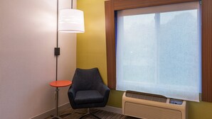 A corner room with a chair, a lamp, and an air conditioning unit. - Holiday Inn Express Branford-New Haven by IHG (Branford)