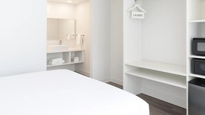 A modern bathroom with a white vanity, a mirror, and a hanging towel rack labeled "LAUNDRY". - Oneway Brunswick (Brunswick)