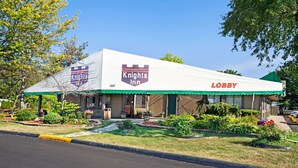 Un hotel Knights Inn con un toldo verde y un cartel que dice 'Lobby'.