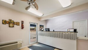 A reception area with a coffee-themed wall art, a reception desk, and a view of the outside. - SureStay Hotel by Best Western Sarasota Lido Beach (Sarasota)