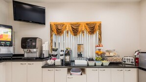 A kitchenette with a coffee maker, toaster, and a beverage dispenser. - SureStay Hotel by Best Western Sarasota Lido Beach (Sarasota)