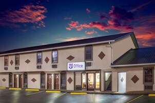 A building with a sign reading "Office" and multiple doors, likely a hotel or office building.