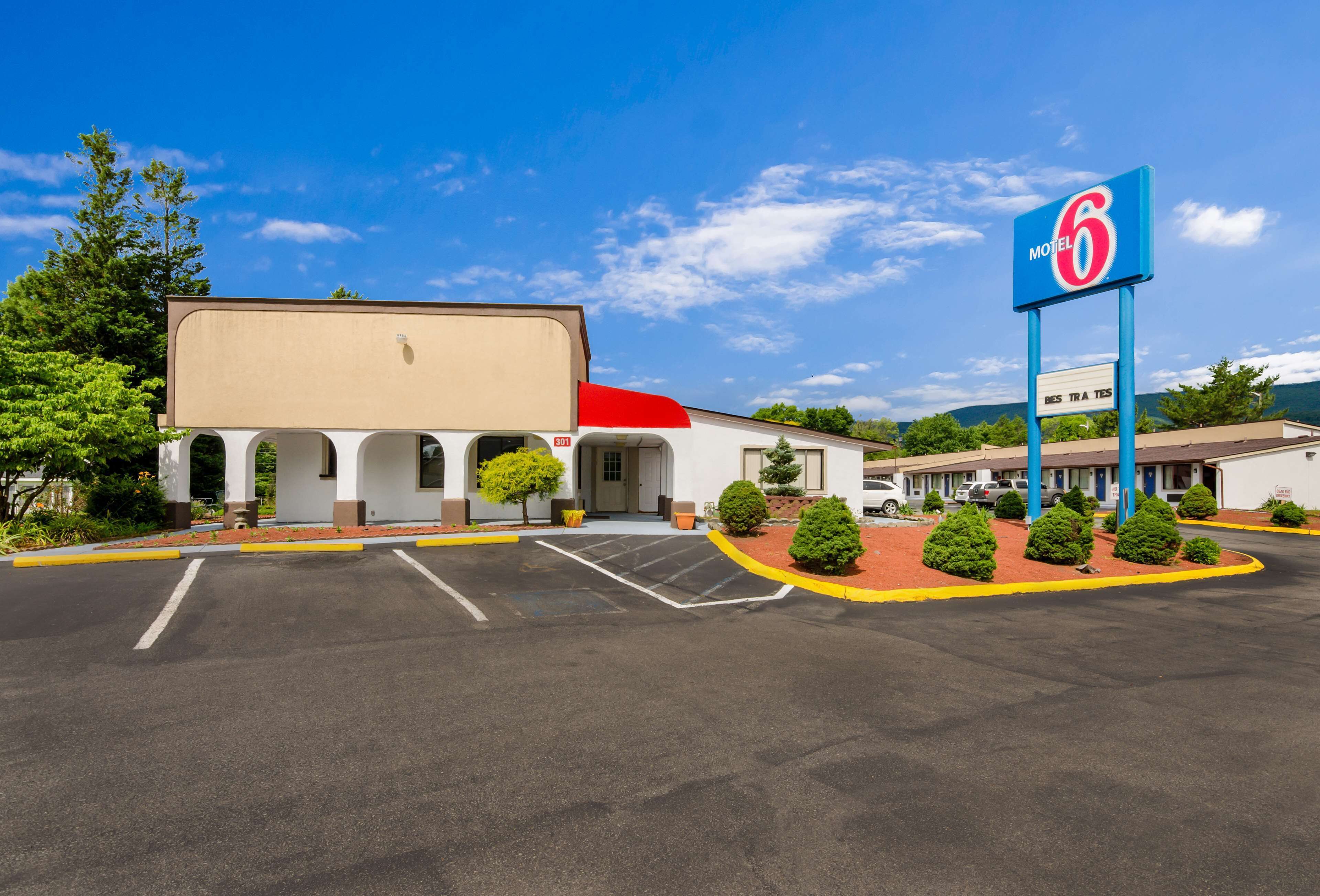 A motel with a large sign reading "Motel 6" and a parking lot in front.