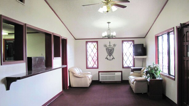 A room with a ceiling fan, two windows with decorative glass panes, a mounted television, and a radiator. - M Star Columbus North (Columbus)