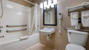 A bathroom with a bathtub, a sink, a toilet, a shower, and a hairdryer.
