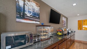 A hotel kitchen with a microwave, toaster, and bread display. - Best Western Muncie (Muncie)
