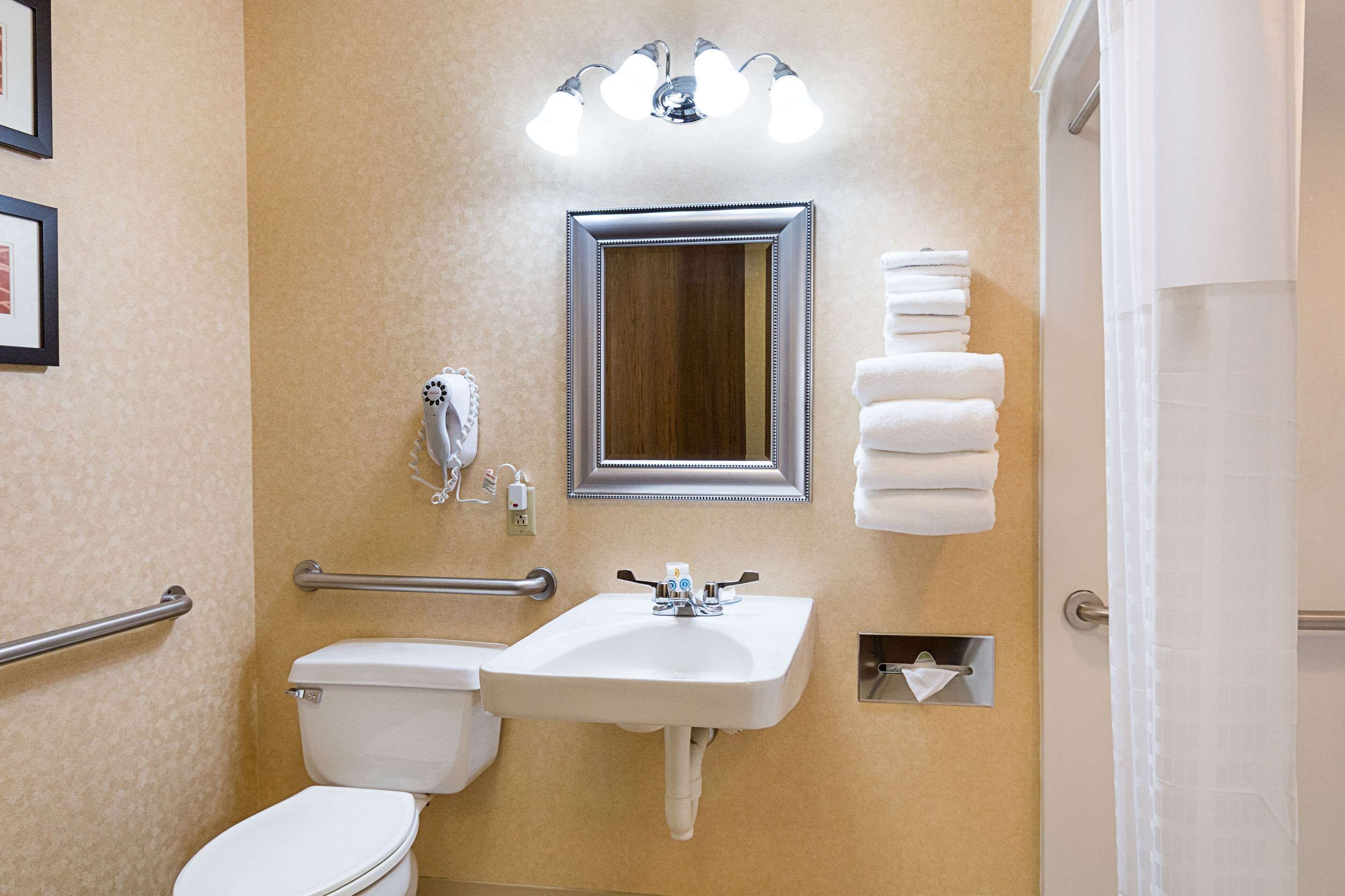 A bathroom with a white sink, a mirror, a toilet, and a towel rack.