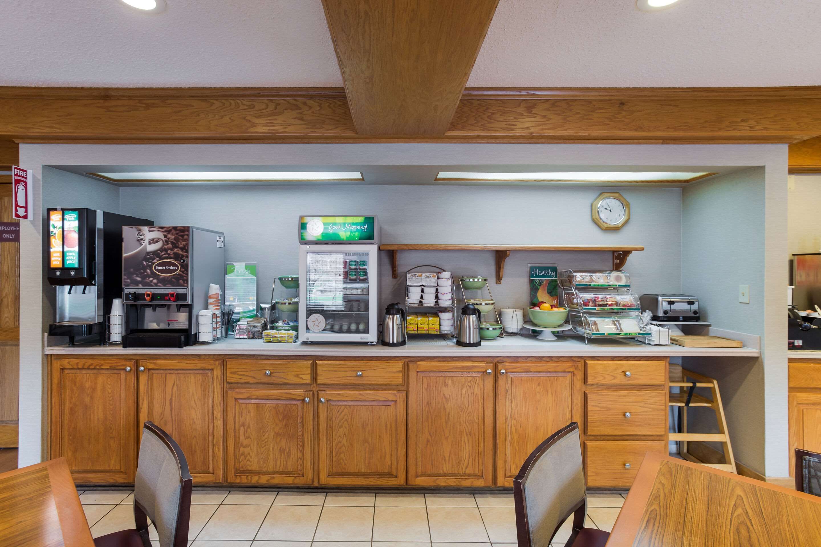 Un coin cuisine équipé de meubles en bois, d’une machine à café, d’un réfrigérateur et de divers appareils de cuisine.