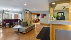 A modern living room with a sofa, dining area, and kitchen in the background. - Quality Inn Athens (Athens)