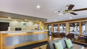 A hotel reception area with a reception desk, seating area, and large windows. - Quality Inn Athens (Athens)