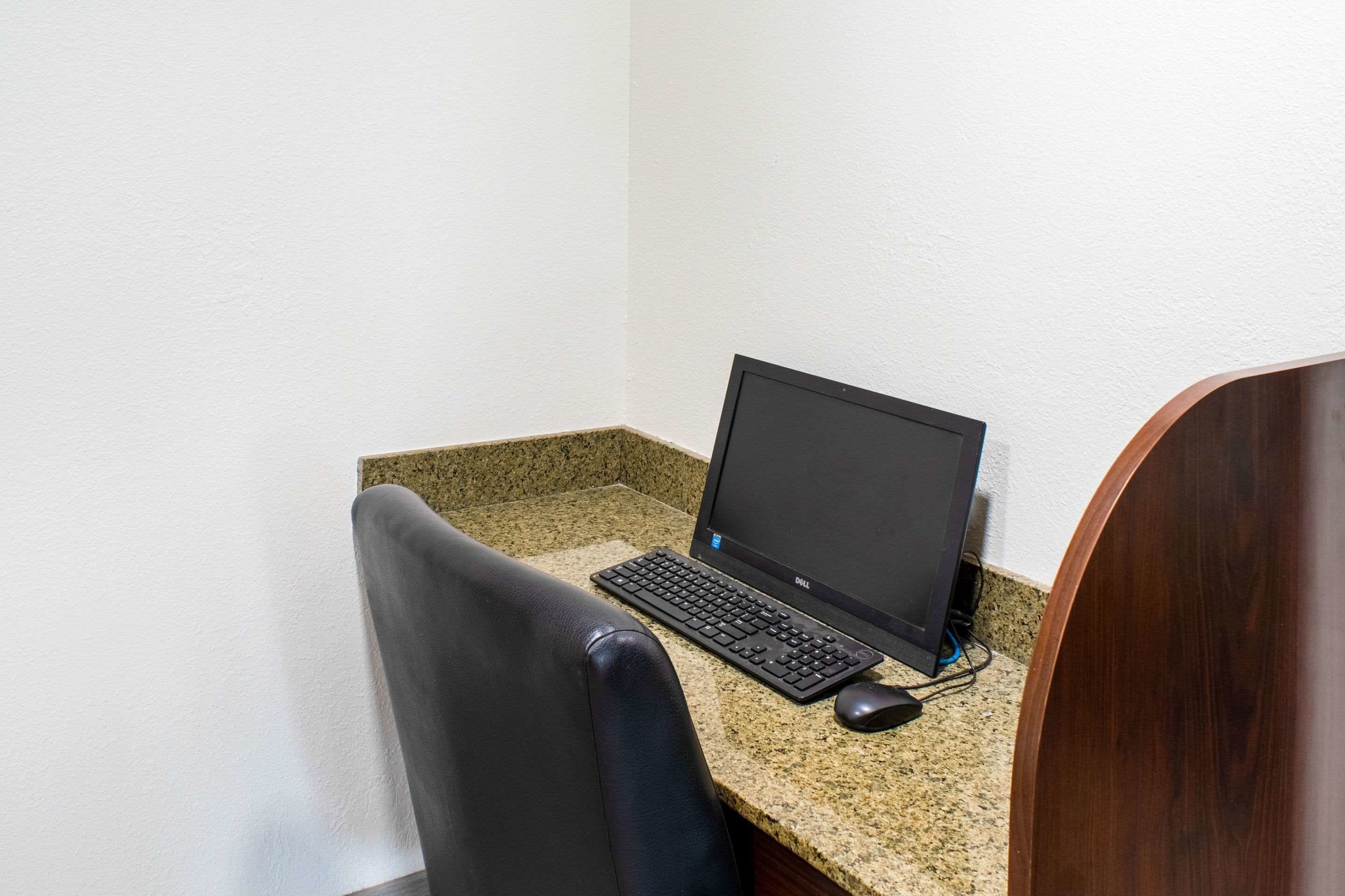 Un bureau d’angle équipé d’un ordinateur portable, d’un clavier et d’une souris, le tout posé sur un bureau en granit.