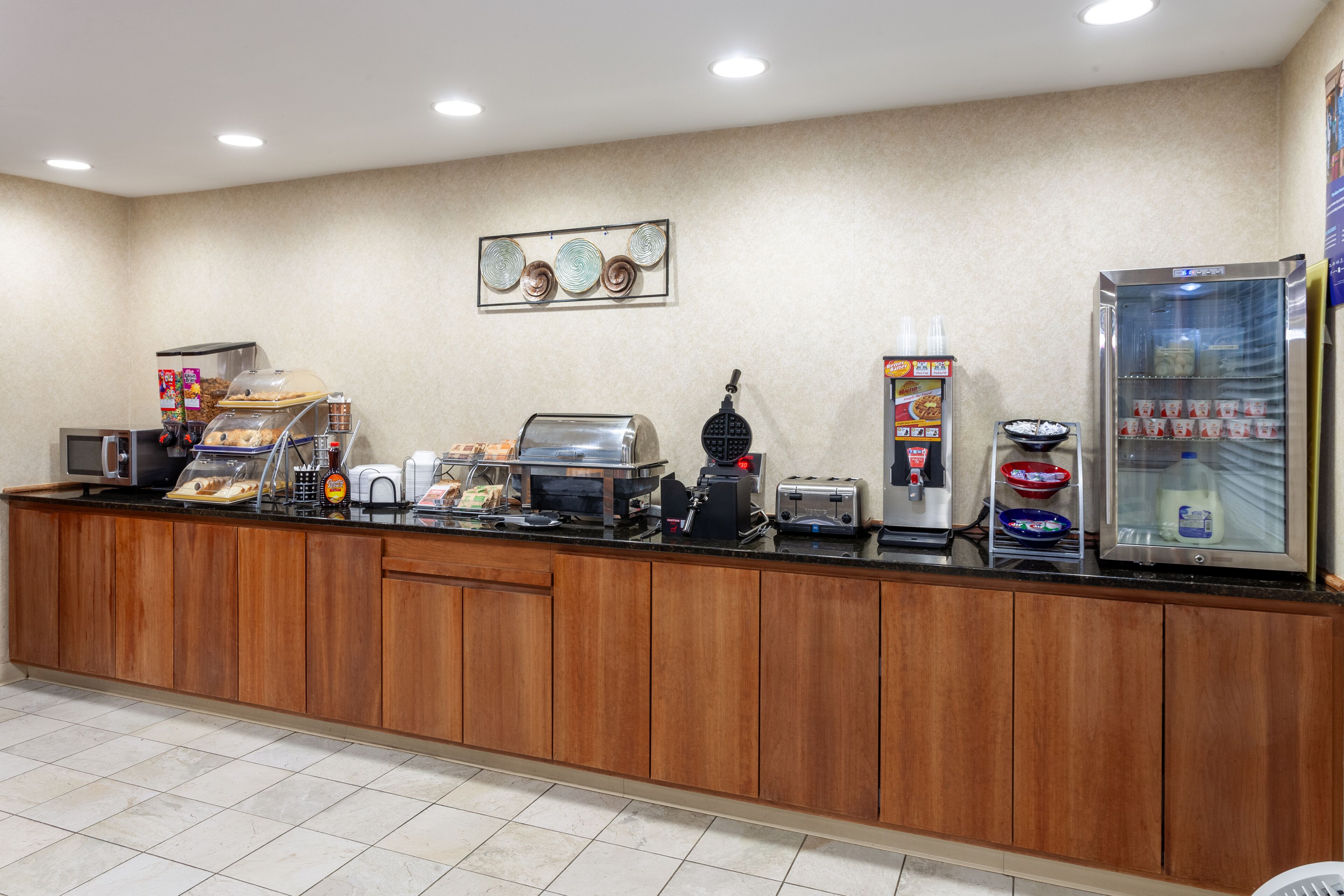 A breakfast bar with a coffee machine, toaster, and various food items.