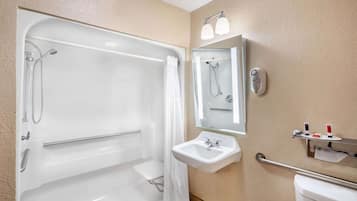A bathroom with a bathtub, a sink, a toilet, and a mirror.
