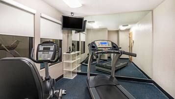 A gym with exercise equipment including a treadmill, stationary bike, and weight machine.