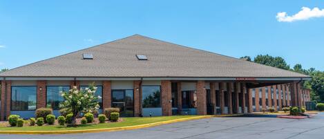 A single-story building with a flat roof, large windows, and a covered entrance area.