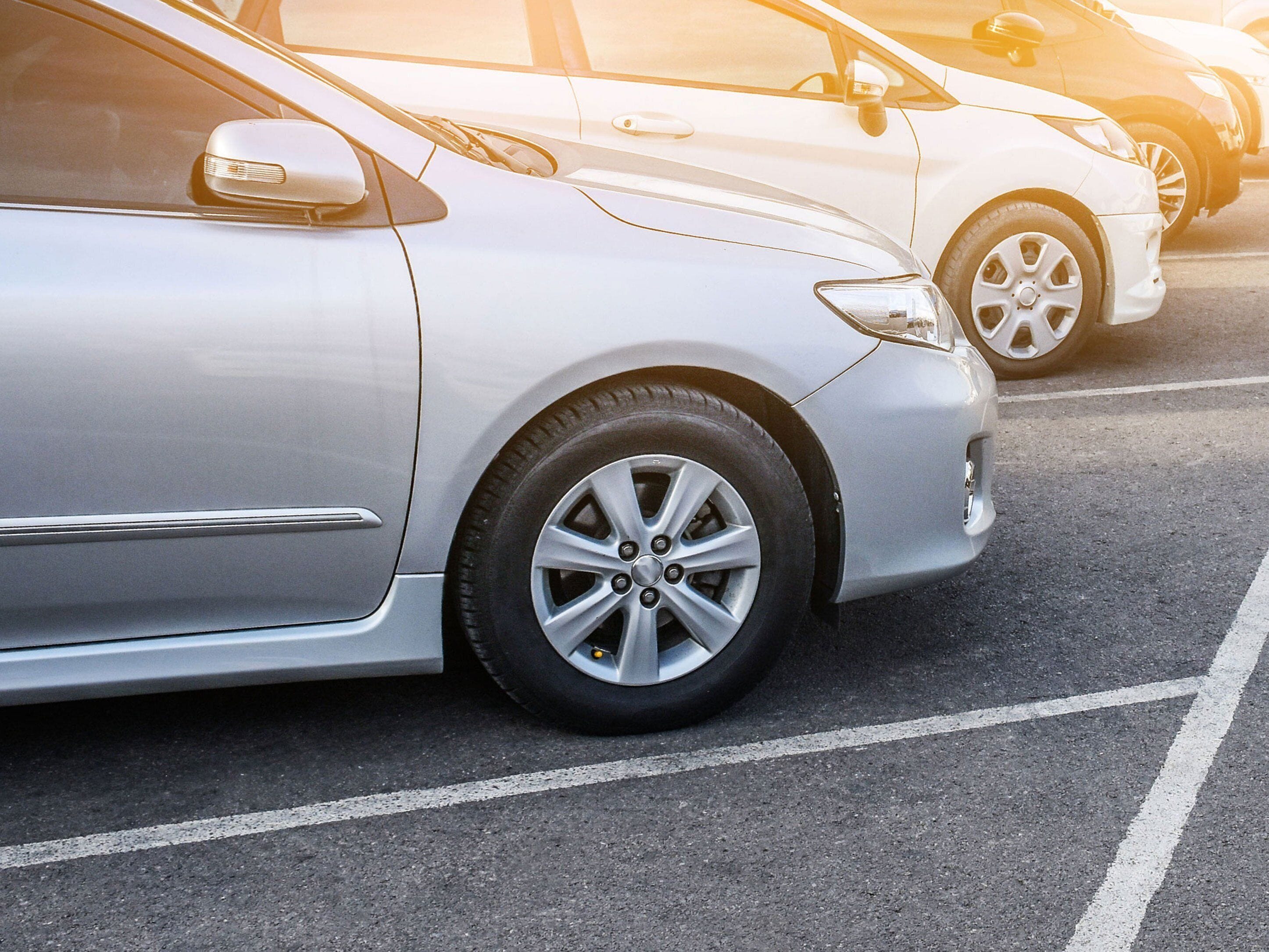 Un estacionamiento con coches estacionados en espacios delimitados.
