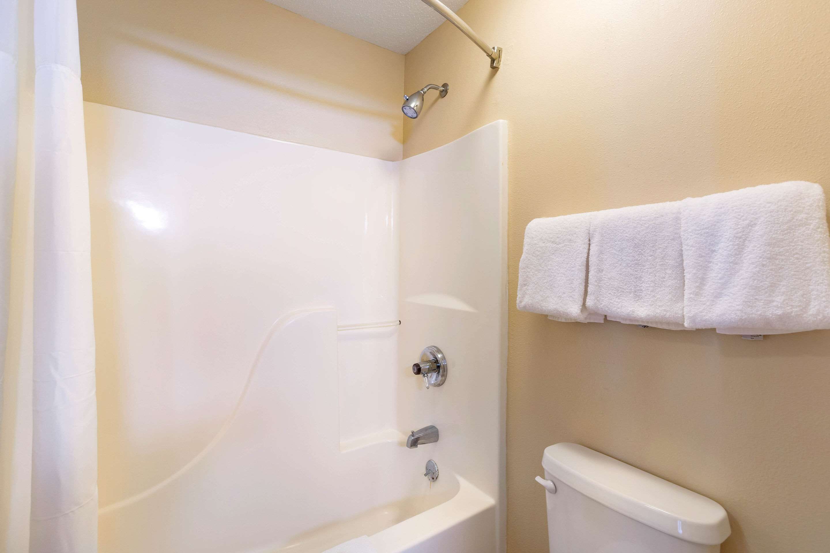A bathroom with a bathtub, a toilet, and a towel rack.
